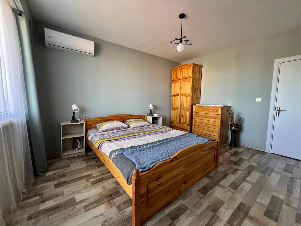 Тристаен апартамент Park View في تارغوفيشته: غرفة نوم بسرير خشبي وخزانة خشبية