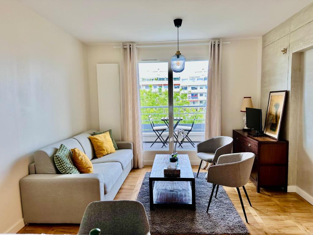 un salon avec un canapé, des chaises et une table dans l'établissement T3 balcon parking clim 3mn pied metro 8 et T3, à Paris
