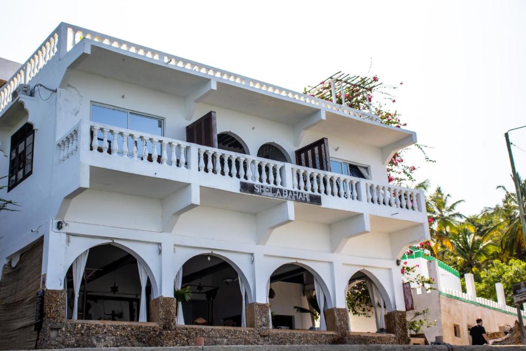 a white building with a balcony at Shela Bahari in Shela