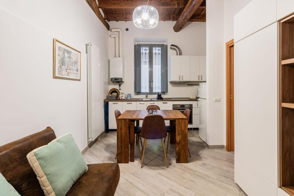 uma cozinha e sala de jantar com uma mesa e um sofá em Homeby - Apartment Anna Maria em Corsico