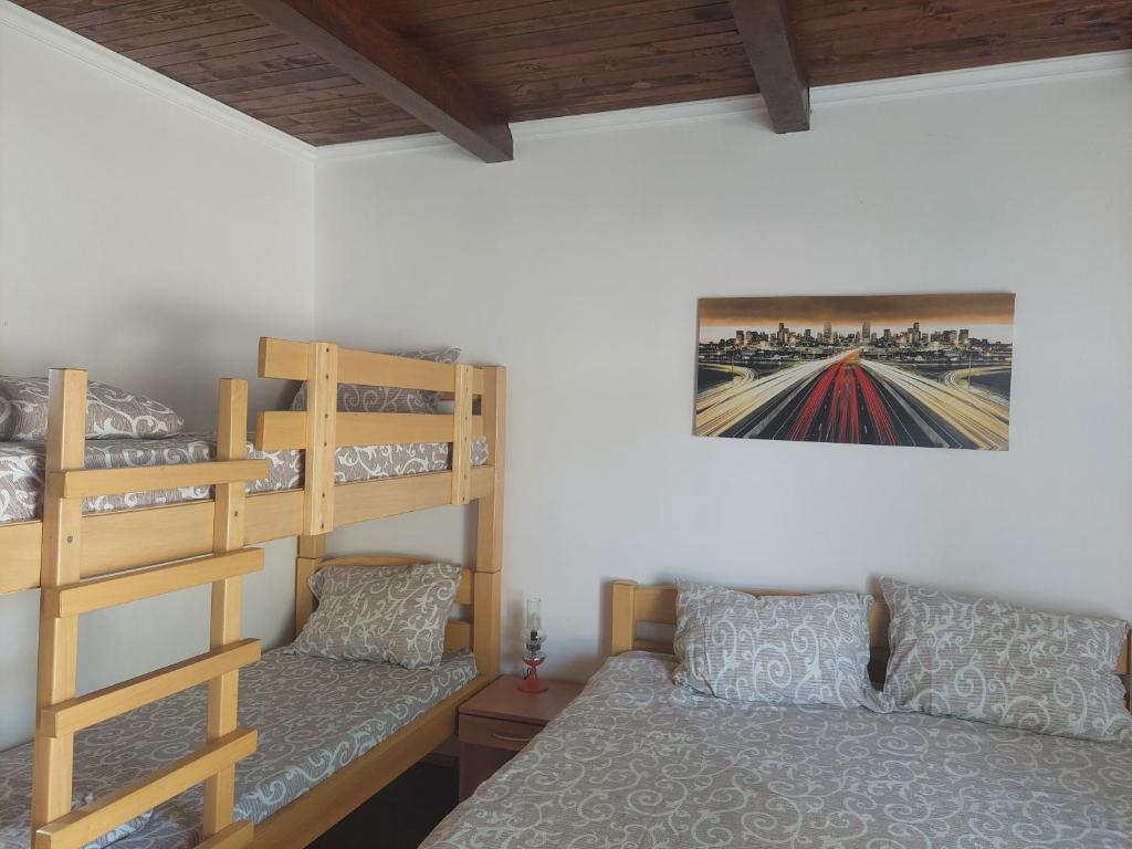 una camera con un letto a castello, un letto e un divano di Apartment M&M a Pačir