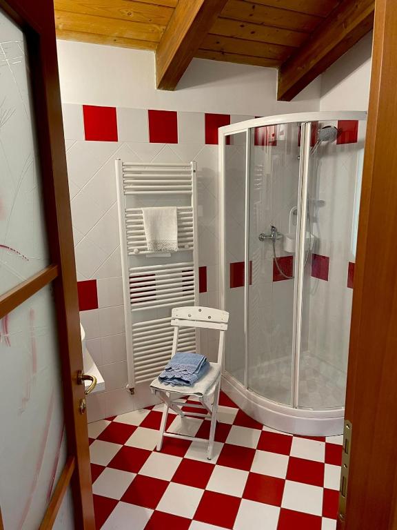 łazienka z prysznicem i krzesłem w pokoju w obiekcie L'Angolo di Leo w mieście Borgofranco dʼIvrea
