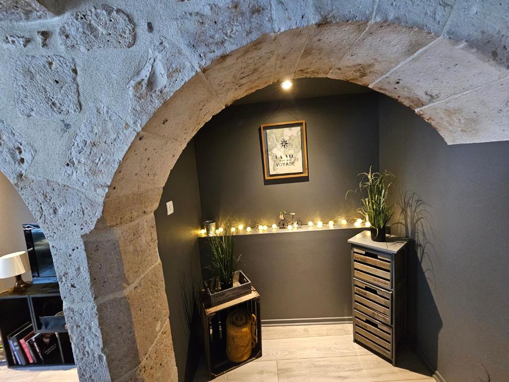 une pièce avec une arche avec des lumières et une commode dans l'établissement La Clé de Voûte, duplex atypique, à Gien