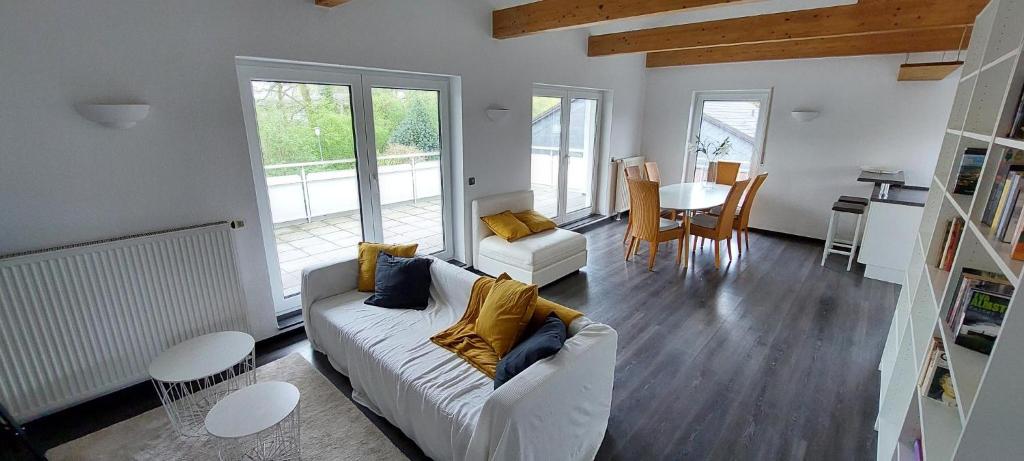 a living room with a white couch and a table at Gemütliche Ferienwohnung am Schwimmbad in Lengerich
