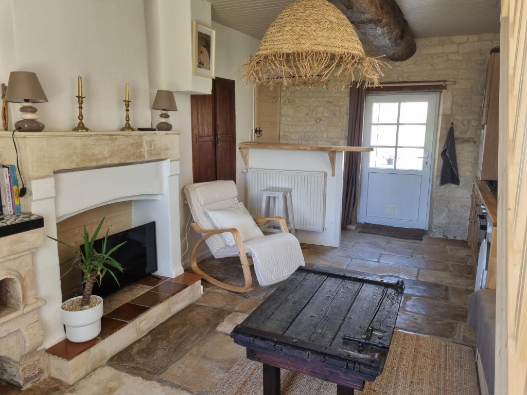 un salon avec une cheminée et une table dans l'établissement les gites d'Adirya, à Saint-Mard