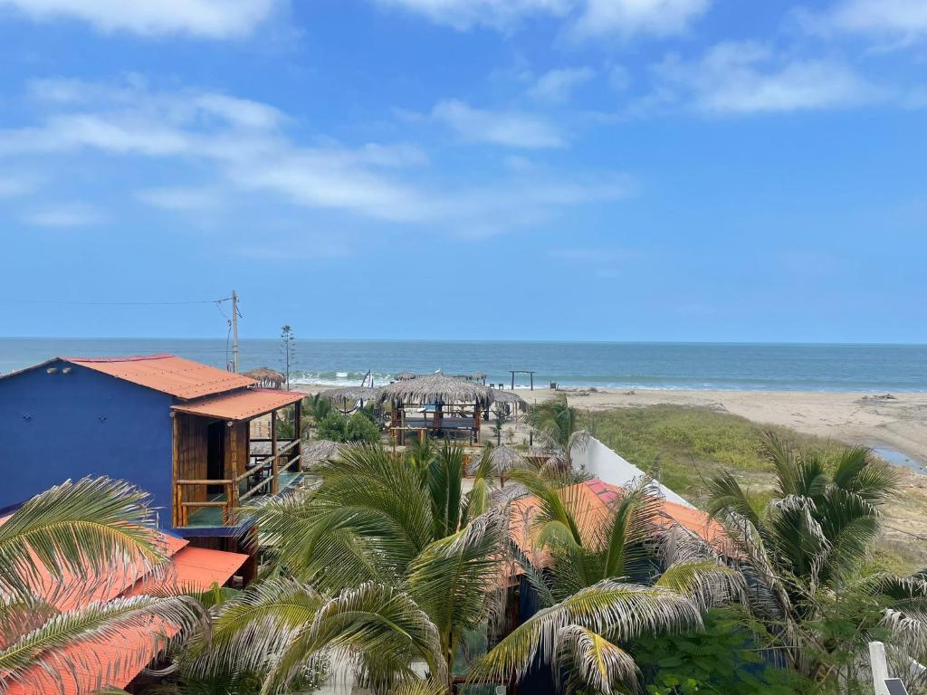 una casa en la playa con palmeras y el océano en Un Dia Boutique Resort, en Playas