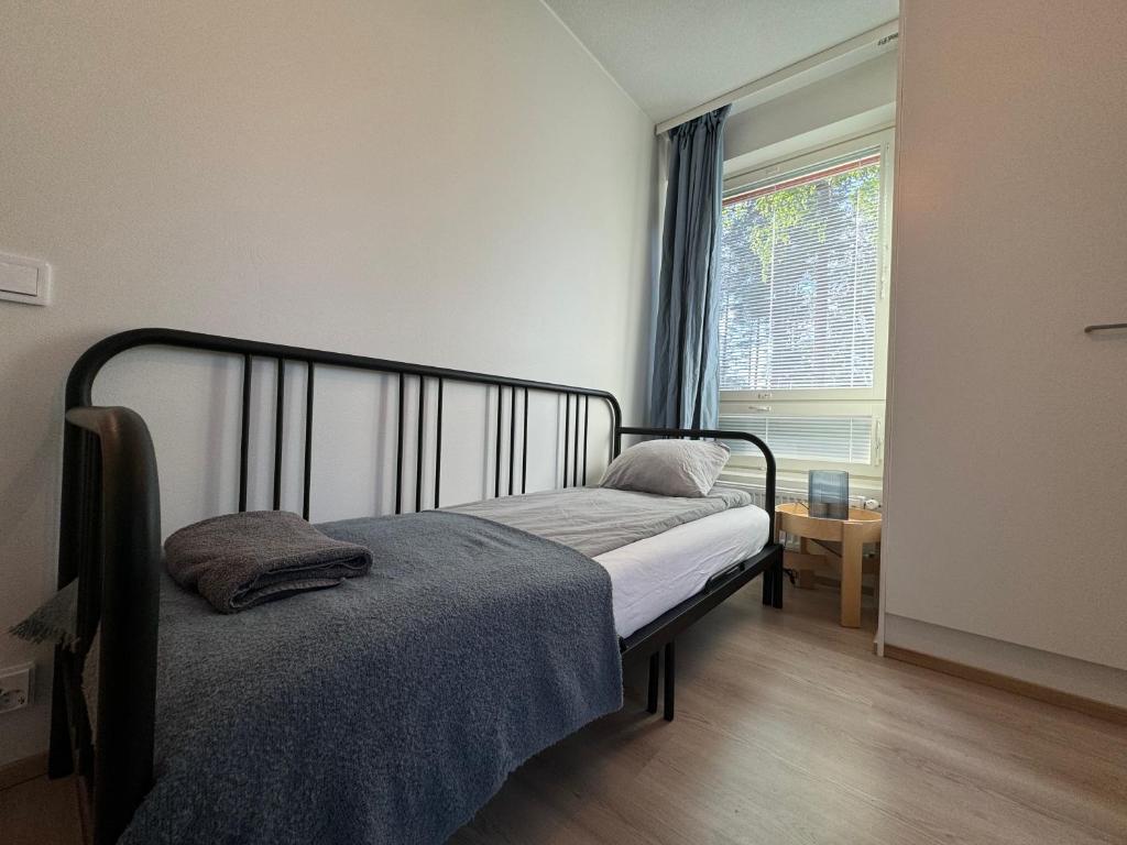 a small bedroom with a bed and a window at Sleep and fly room - Homestay in Vantaa