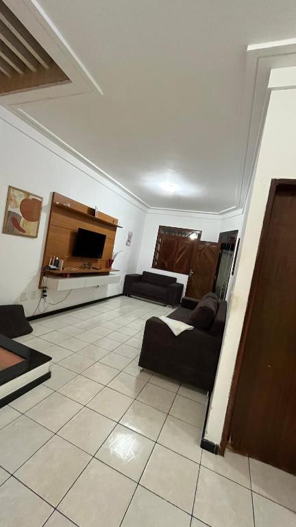a living room with a couch and a table at Casa farolândia in Aracaju