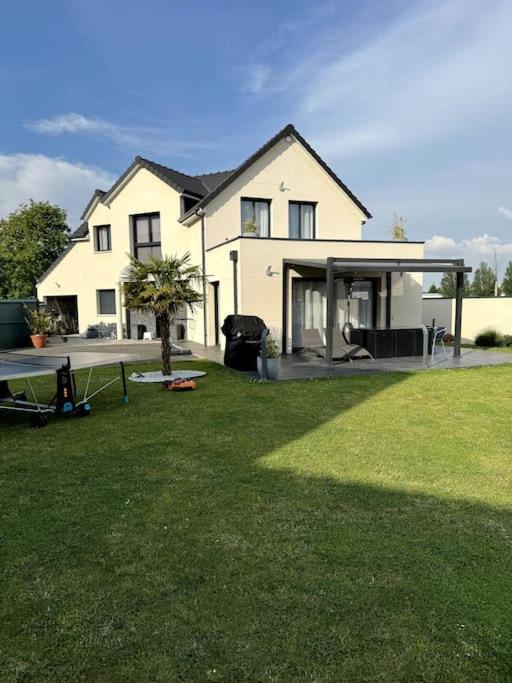 une maison avec une cour et une table devant elle dans l'établissement belle maison avec piscine chauffée sans vis-à-vis, à Caudebec-lès-Elbeuf