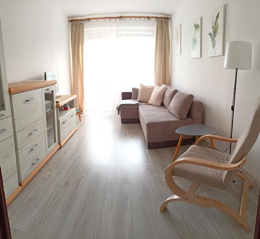 a living room with a couch and a chair at Apartament Mazury in Olecko