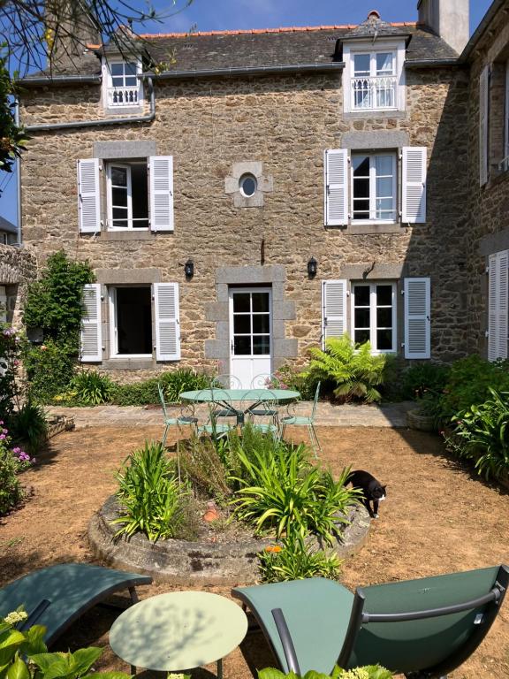 une maison avec des chaises et un chien devant elle dans l'établissement Ker Heol, à Saint-Malo
