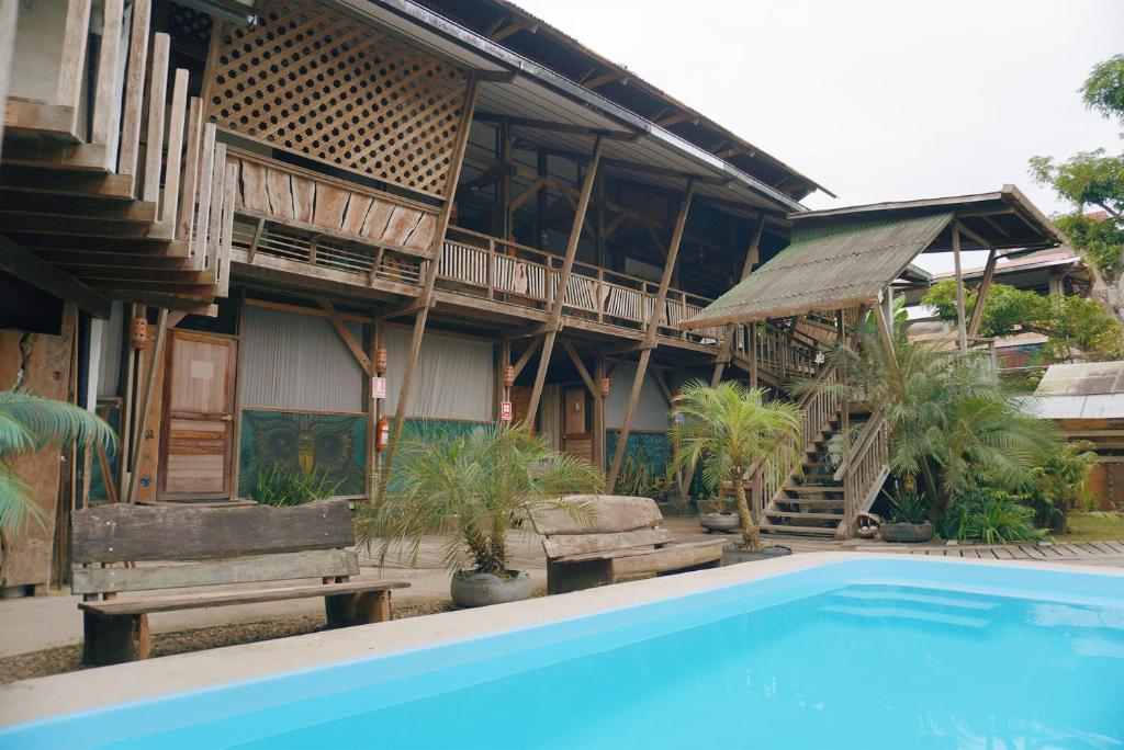 dom z basenem przed nim w obiekcie La Fauna Hotel w mieście Puerto Maldonado
