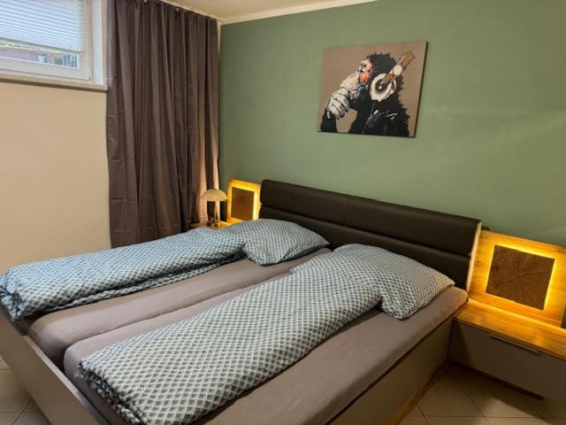 a bedroom with a bed with a picture on the wall at Ferienwohnung Pappelwiese in Weimar
