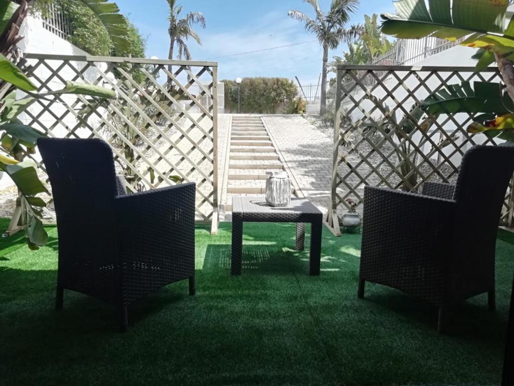 a patio with two chairs and a table in the grass at Sole&Mare in Monopoli