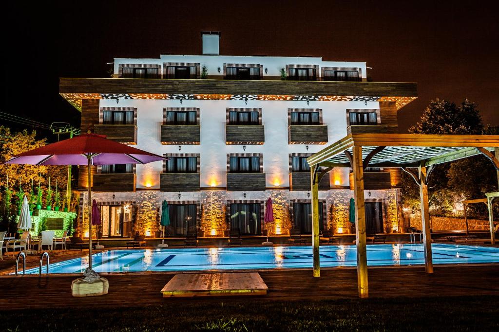 a hotel with a swimming pool in front of a building at My Green Boutique Hotel in Masukiye