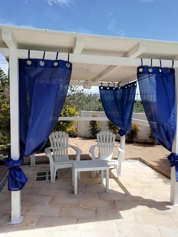 a gazebo with two chairs and blue curtains at Sole&Mare in Monopoli