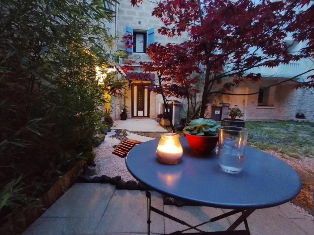 une table bleue avec une bougie et deux bougies dessus dans l'établissement Le Petit d'Aquí appartement d'hôtes - 15 minutes de la mer, à Montblanc