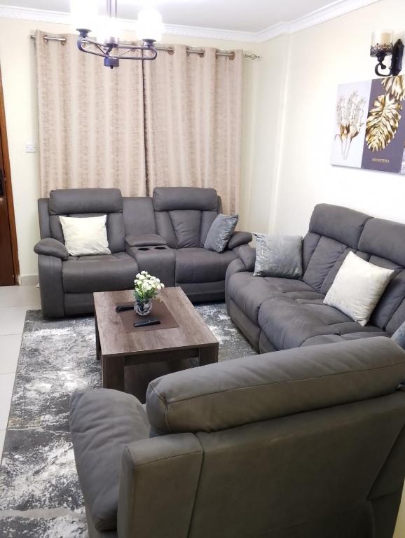 Jamhuri Executive Suites في نيروبي: غرفة معيشة مع كنب وطاولة قهوة