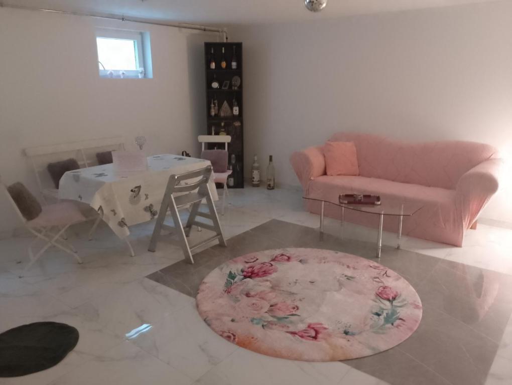 ein Wohnzimmer mit einem rosa Sofa und einem Tisch in der Unterkunft Durchreisestop mit Kinder am außergewöhnlichen Spitzboden mit Autobetten und Bad ,Küche im Souterain in Deining