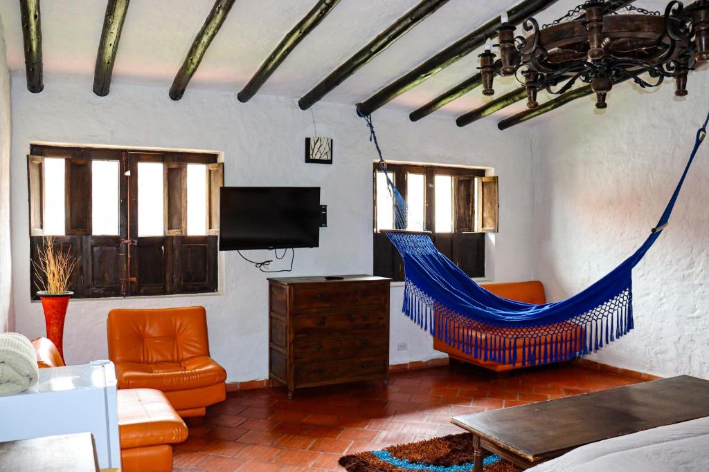 a living room with a blue hammock in a room at Casona Quesada in Suesca