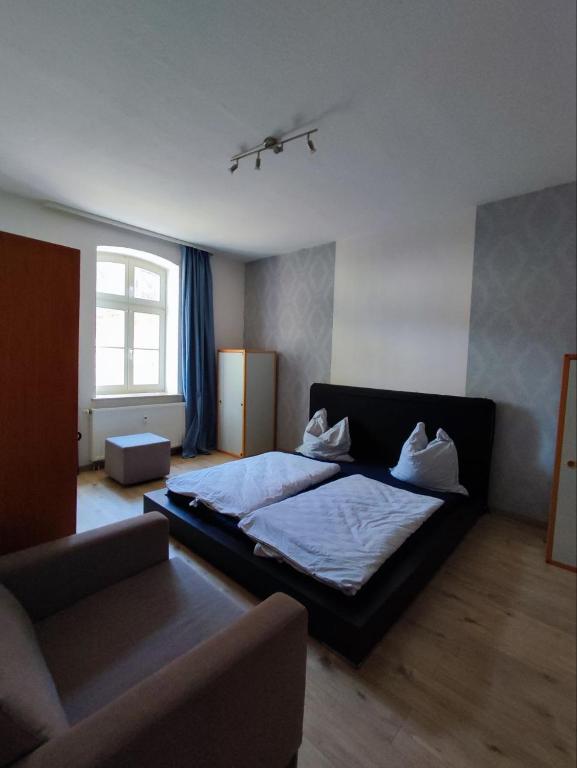a bedroom with a bed and a couch at Haus am See Annahütte - für bis zu 6 Personen in Schipkau