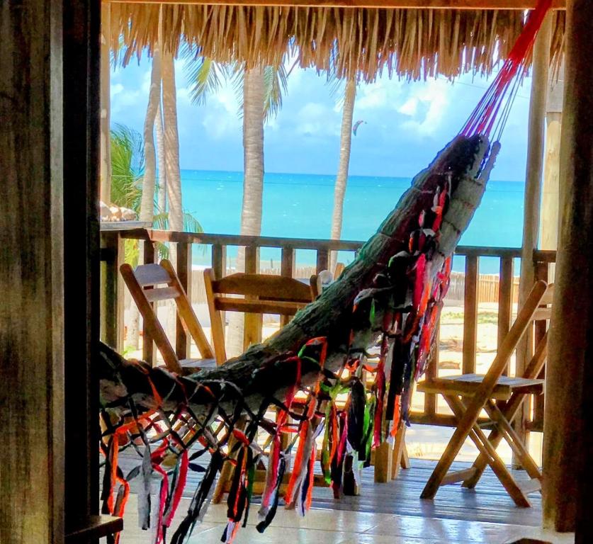 a hammock on a porch with a view of the ocean at Pousada Tangerina in Icaraí