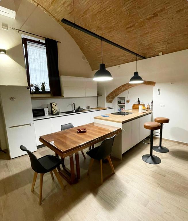 a kitchen with a wooden table and chairs at La Buona Volta in Montalbano Ionico