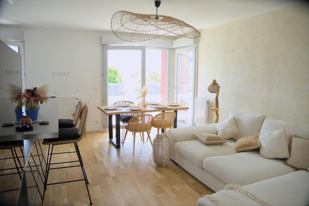 un salon avec un canapé blanc et une table dans l'établissement Appartement Moderne et Spacieux, à Créteil