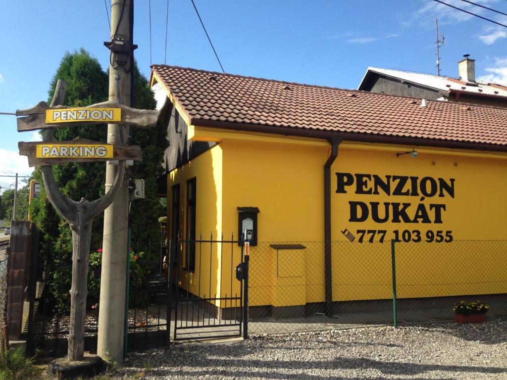 um edifício amarelo com um cartaz que diz "drupal da pensão" em Penzion Dukát em Vřesina