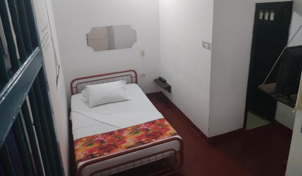 Hostel La Casona 1859 في غوادواس: غرفة صغيرة مع سرير صغير في غرفة