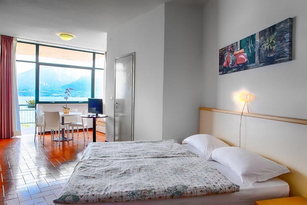 sypialnia z łóżkiem i jadalnia ze stołem w obiekcie Residence Wieland w mieście Torri del Benaco