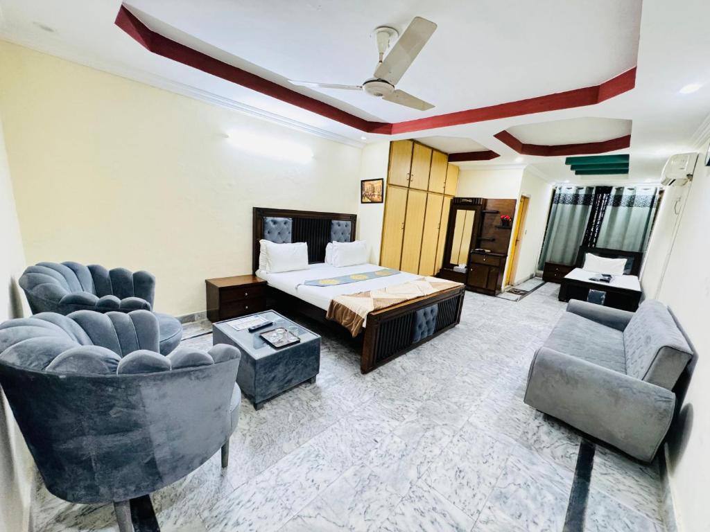 sala de estar con 1 cama y 2 sillas en Lexus Lodge, en Islamabad