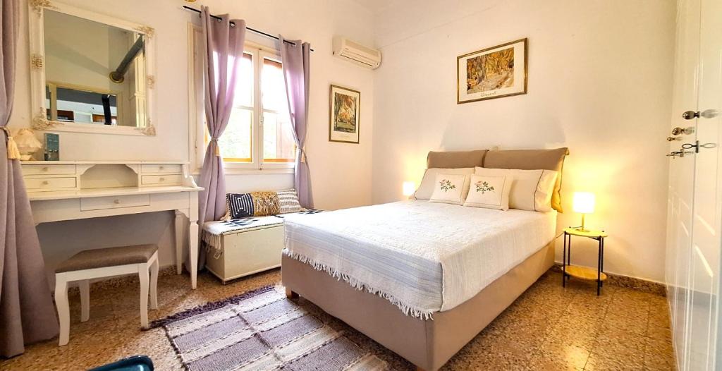 una camera da letto con un letto, una scrivania e uno specchio di Gaia Estate a Calimno (Kalymnos)