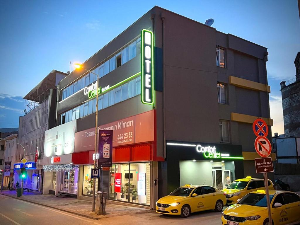 dos taxis amarillos estacionados frente a un edificio en Comfort Center Suit Hotel en Edirne
