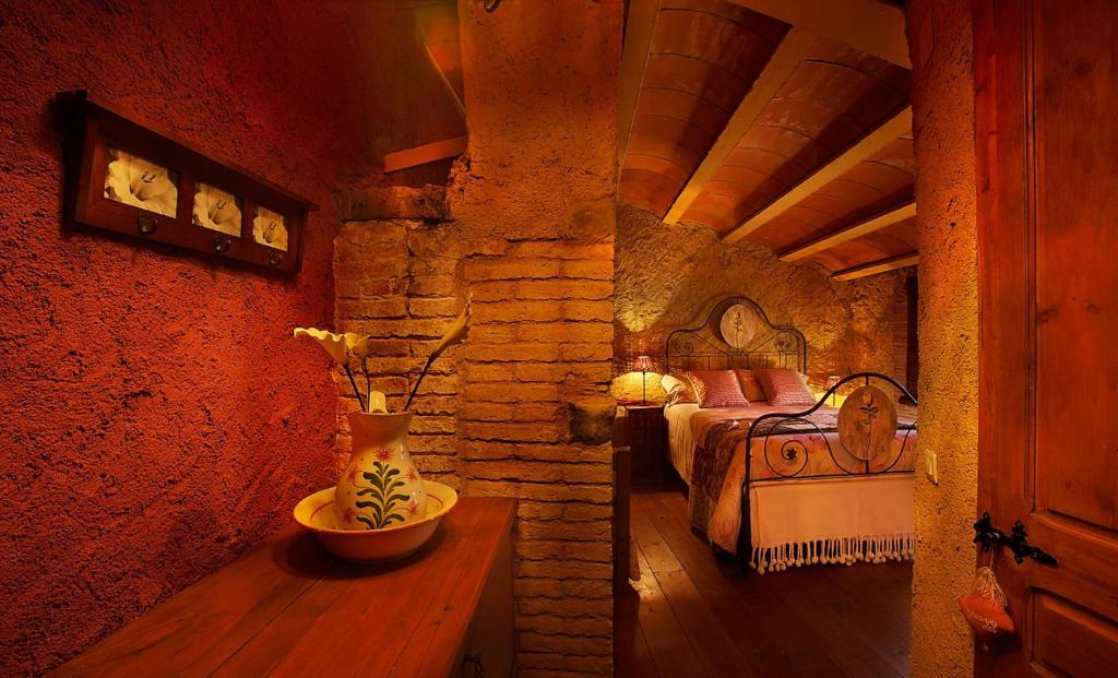 コルノデイヤにあるMasia El Canalot - Molí Del Pontのベッドルーム1室(ベッド1台、テーブル上の花瓶付)