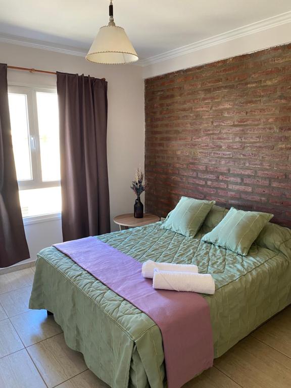 ein Schlafzimmer mit einem großen Bett mit Ziegelwand in der Unterkunft Complejo Pampa in Santa Rosa
