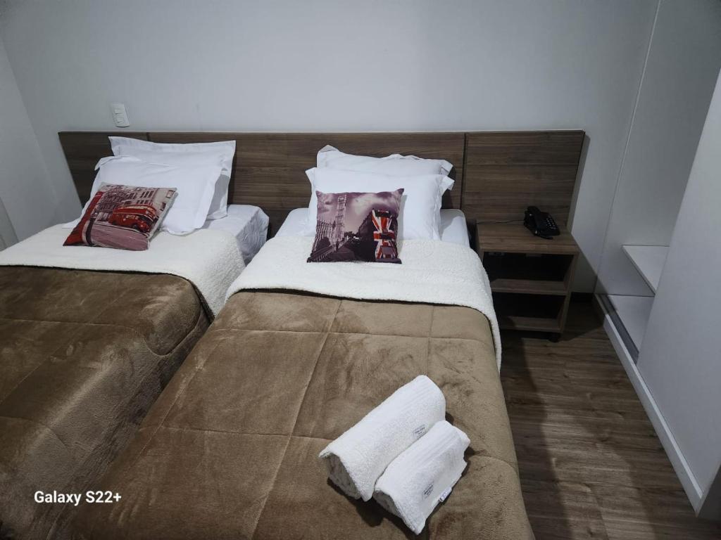 Dos camas en una habitación con toallas. en Suíte Barra Olimpica/Rio Centro/Jeunesse Arena., en Río de Janeiro