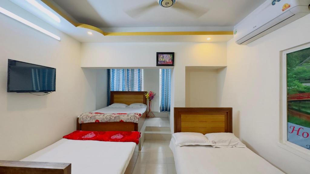 a small room with two beds and a tv at Hotel Panthapath Dhaka in Dhaka
