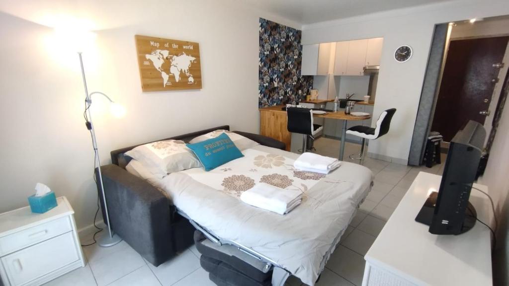 une petite chambre avec un lit et une cuisine dans l'établissement Cannes 20' à pieds Palais wifi, à Cannes