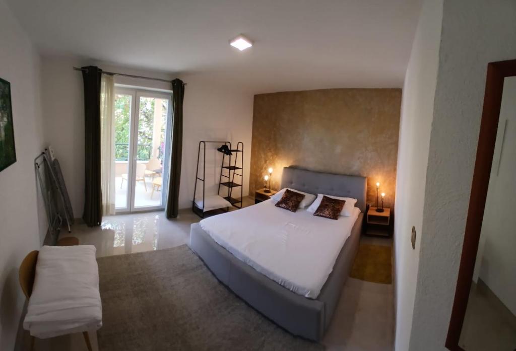 1 dormitorio con cama blanca y ventana en Apartmani kike, en Makarska