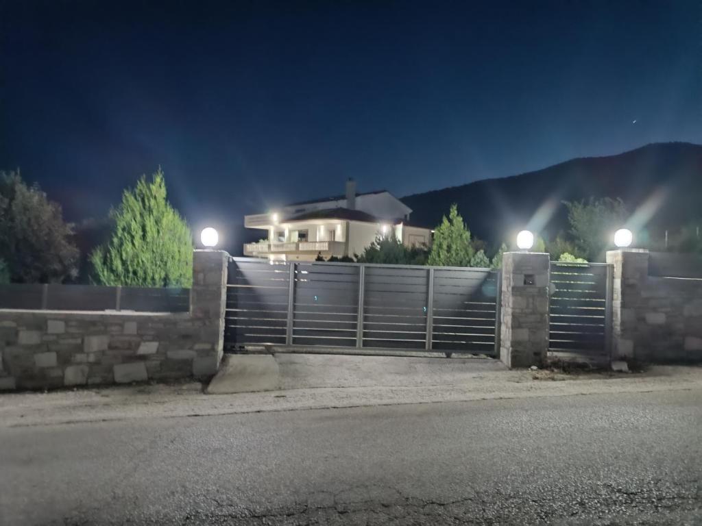 una casa con una recinzione davanti a una casa di notte di Olive Waves apartments a Néa Péramos