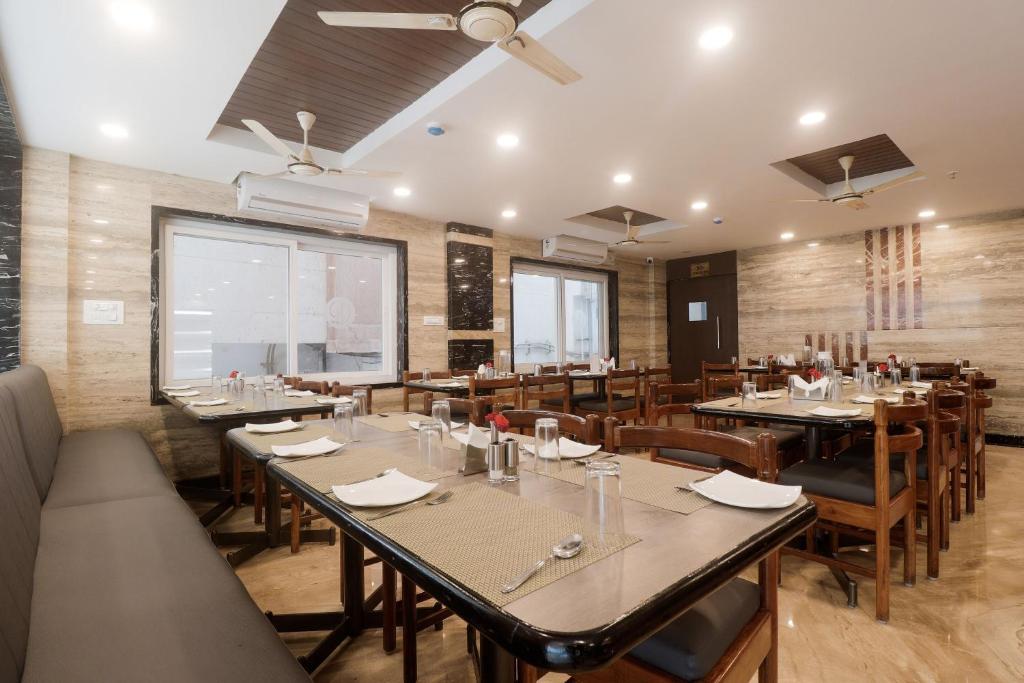 un restaurante con mesas y sillas y una gran ventana en Townhouse Hotel Dj Grand en Tirupati