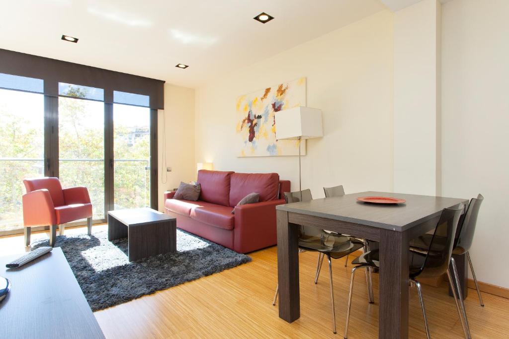 a living room with a red couch and a table at Weflating Modern Diagonal in Barcelona