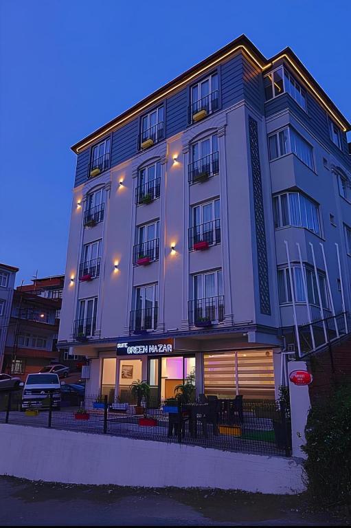 a large white building with tables in front of it at Green Nazar Hotel in Trabzon