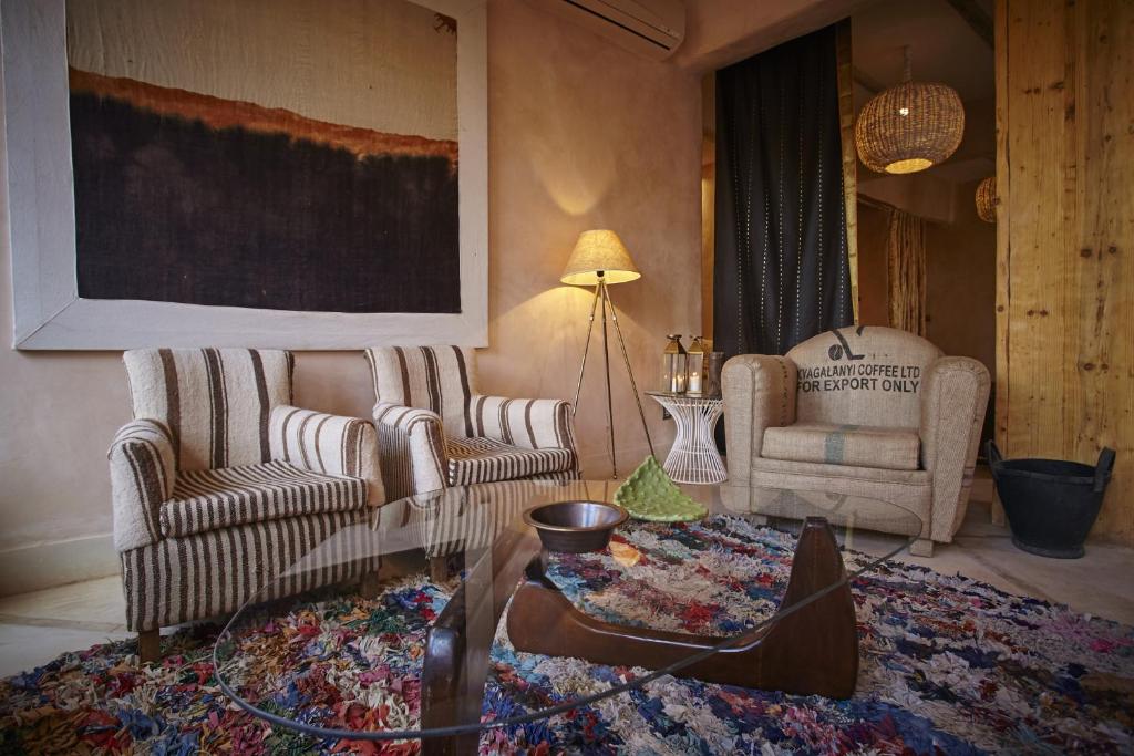 uma sala de estar com duas cadeiras e uma mesa de centro em Riad Caravane em Aït-Ben-Haddou
