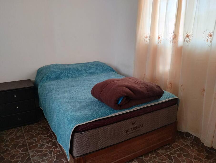 a bed with a red towel on top of it at Casa Valle de Sur in Durango