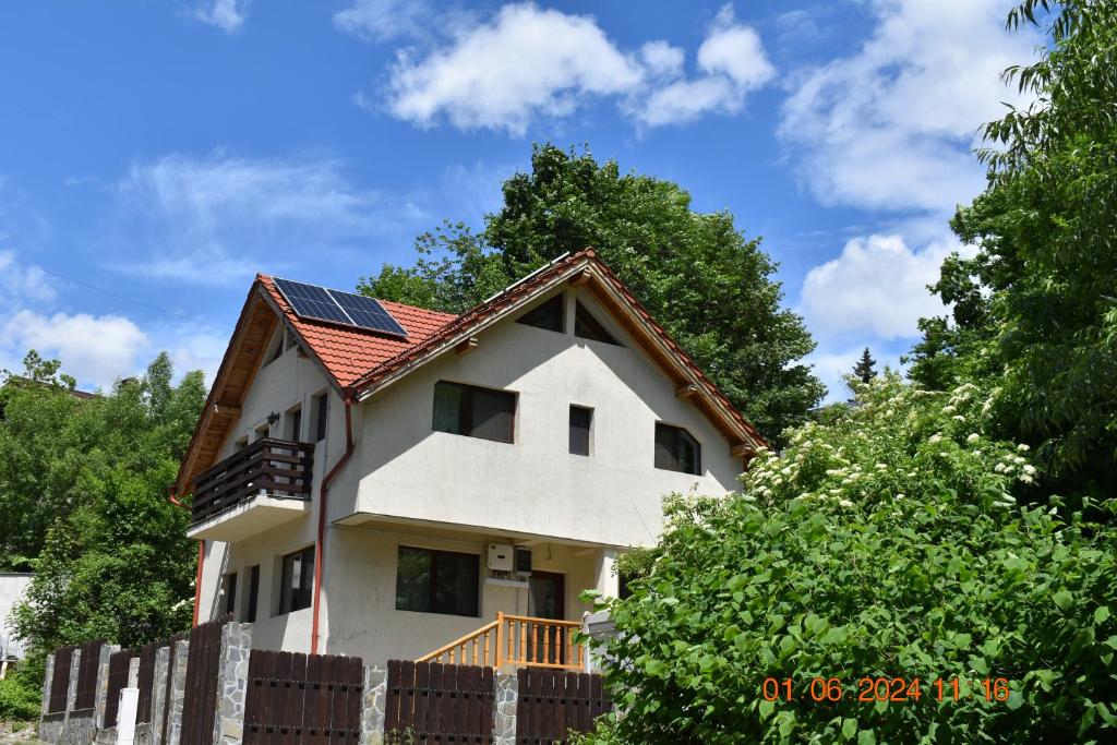 a white house with solar panels on the roof at Capra cu trei iezi in Sinaia