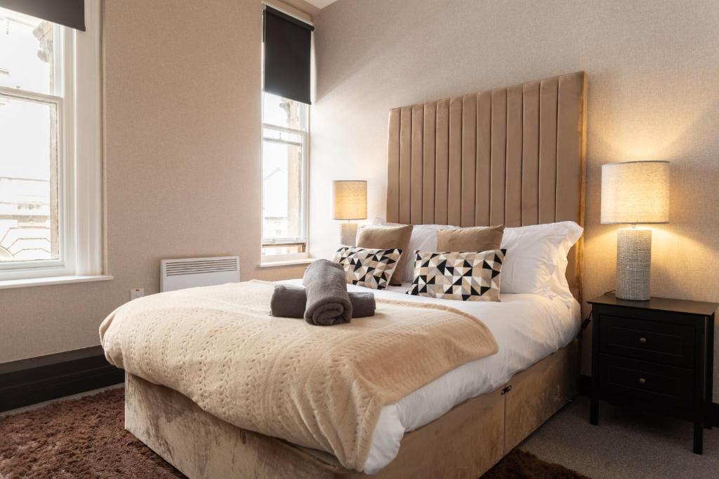 a bedroom with a large bed with two lamps on it at Crown Street Aparthotel in Halifax