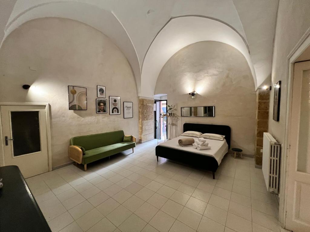 a bedroom with a bed and a green couch at Handy Pergola in Brindisi