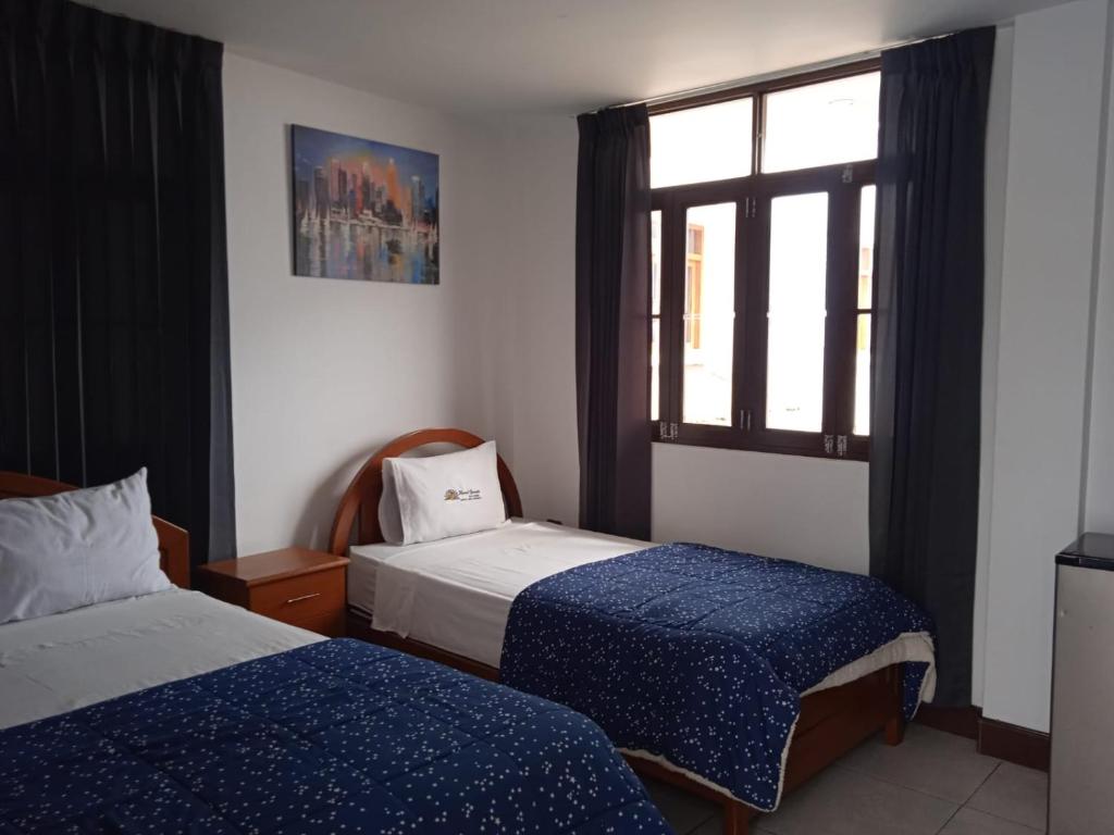 um quarto com 2 camas e uma janela em Hotel Garuda Pimentel em Pimentel